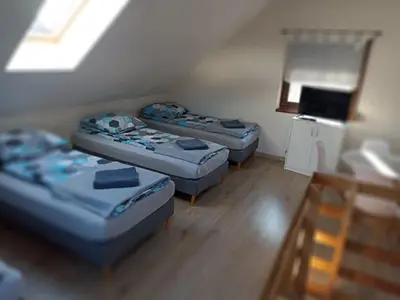 a room with three beds in it with a window at Mała Chatka domek Zator Oświęcim in Polanka Wielka
