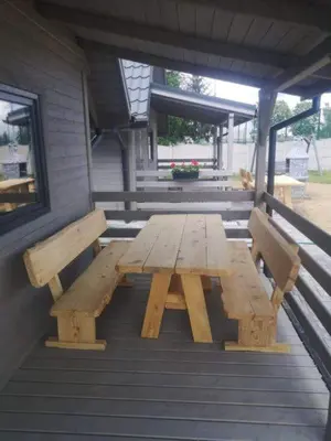 a wooden picnic table and two benches on a porch at Domki Całoroczne Danielowa Ostoja-Zator,Palczowice in Zator
