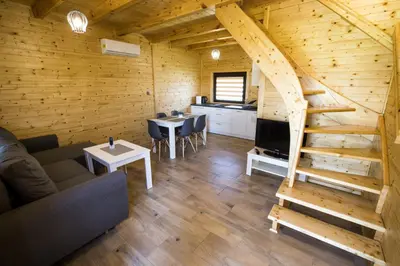 a living room with a staircase in a log cabin at Domki Całoroczne Danielowa Ostoja-Zator,Palczowice in Zator