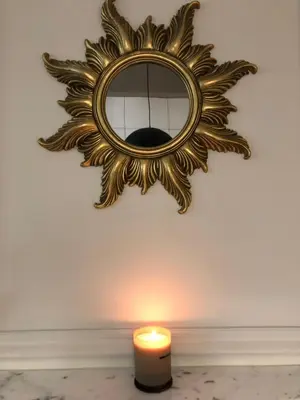 a candle and a mirror on a wall next to a candle at POETICA APARTMENT in Kraków