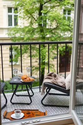 a table on a balcony with a tray of pastries at POETICA APARTMENT in Kraków