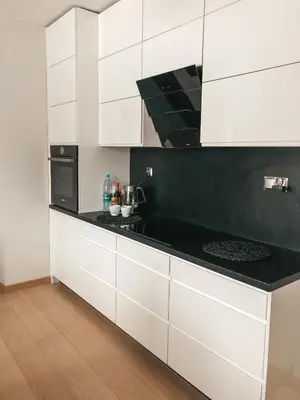 a kitchen with white cabinets and a black counter top at Jaszczurowa Apartament II in Jaszczurowa
