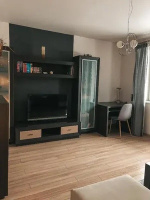 a living room with a flat screen tv and a desk at Jaszczurowa Apartament II in Jaszczurowa