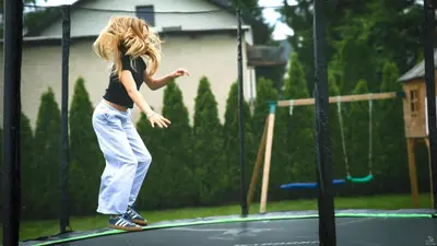 a young girl standing on a trampoline at Calm Village in Zator