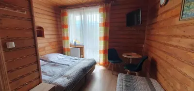 a bedroom with a bed and a table and a window at Diablak in Zawoja