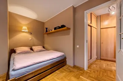 a small bedroom with a bed and a closet at Apartament Kapelanka CoWork in Kraków