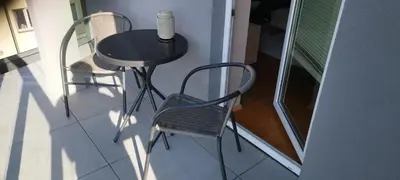 a small black table and chairs on a balcony at Apartament Kapelanka CoWork in Kraków