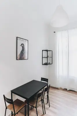 a black dining room table and chairs in a white room at Podzamcze 24 Apartments in Kraków