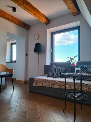 a living room with a couch and a large window at Uroczy apartament w centrum Krakowa in Kraków