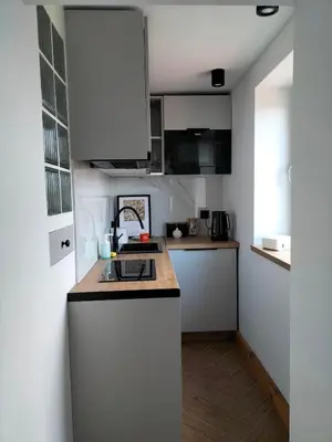 a kitchen with white cabinets and a counter top at Uroczy apartament w centrum Krakowa in Kraków