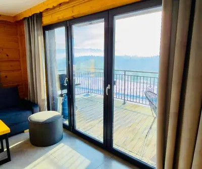 a room with a balcony with sliding glass doors at Tatra Village in PyzÃ³wka