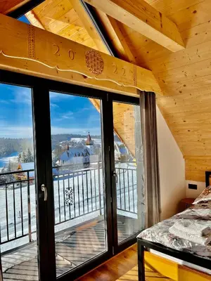 a room with a large window with a view of a mountain at Tatra Village in PyzÃ³wka