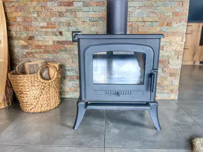 a stove sitting in a room with a brick wall at Tatra Village in PyzÃ³wka