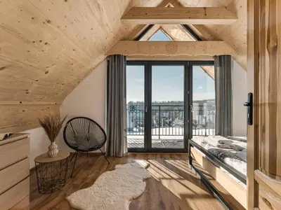 a room with wooden ceilings and a large window at Tatra Village in PyzÃ³wka