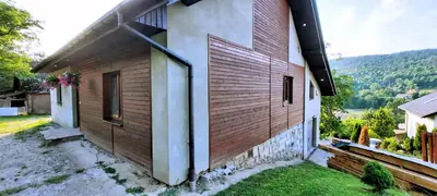 a house with wooden siding on the side of it at Chata u Górala in Stróża