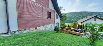 a house with a red wall on the side of it at Chata u Górala in Stróża