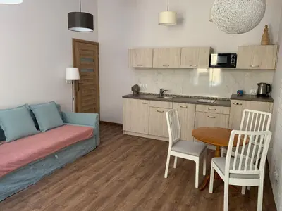 a living room with a couch and a table and a kitchen at Silent Place in Heart of Krakow near Main Station in Kraków