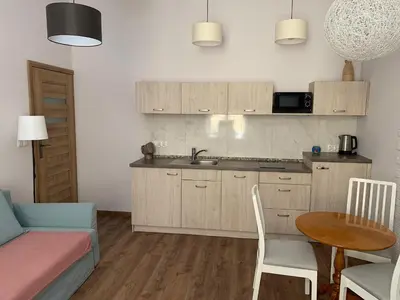 a kitchen with a sink and a table and a couch at Silent Place in Heart of Krakow near Main Station in Kraków