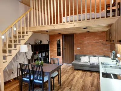 a kitchen and living room with a table and a loft at Silent Place in Heart of Krakow near Main Station in Kraków