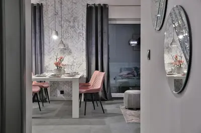 a dining room with a white table and pink chairs at Nowoczesne Apartamenty typu Superior - Bulwary Rabka Zdrój - Balia - Blisko Park Zdrojowy in Rabka