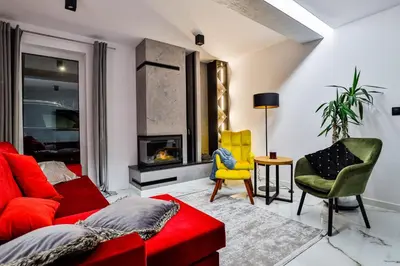 a living room with a red couch and yellow chairs at Nowoczesne Apartamenty typu Superior - Bulwary Rabka Zdrój - Balia - Blisko Park Zdrojowy in Rabka