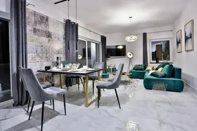 a living room with a table and a green couch at Nowoczesne Apartamenty typu Superior - Bulwary Rabka Zdrój - Balia - Blisko Park Zdrojowy in Rabka