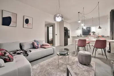 a white living room with a couch and a table at Nowoczesne Apartamenty typu Superior - Bulwary Rabka Zdrój - Balia - Blisko Park Zdrojowy in Rabka