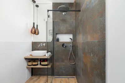 a bathroom with a shower and a sink at Apartments Osiedle Szkolne Cracow by Noclegi Renters in Kraków