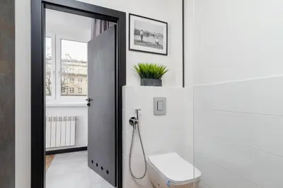a bathroom with a toilet and a mirror at Apartments Osiedle Szkolne Cracow by Noclegi Renters in Kraków