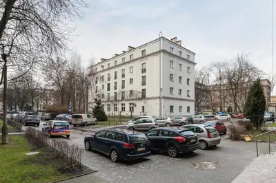 a parking lot with cars parked in front of a building at Apartments Osiedle Szkolne Cracow by Noclegi Renters in Kraków