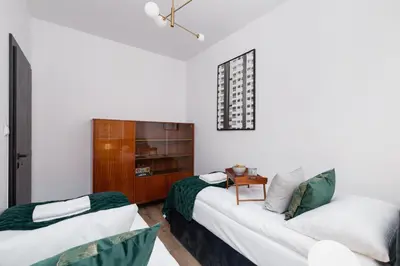 a living room with a couch and a table at Apartments Osiedle Szkolne Cracow by Noclegi Renters in Kraków