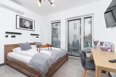a bedroom with a bed and a table and a desk at Modern Studio Cracow Rakowicka 14 by Noclegi Renters in Kraków
