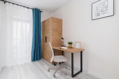 a desk with a chair in a room with a window at Modern Studio Cracow Rakowicka 14 by Noclegi Renters in Kraków