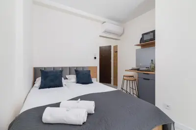 a bedroom with a large bed with two towels on it at Modern Studio Cracow Rakowicka 14 by Noclegi Renters in Kraków