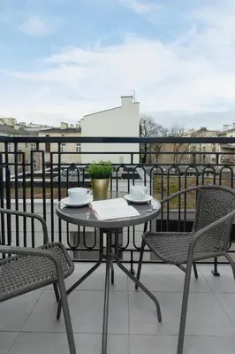 a table and chairs on top of a balcony at Modern Studio Cracow Rakowicka 14 by Noclegi Renters in Kraków