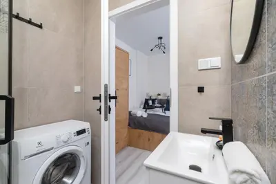a bathroom with a washing machine and a sink at Modern Studio Cracow Rakowicka 14 by Noclegi Renters in Kraków