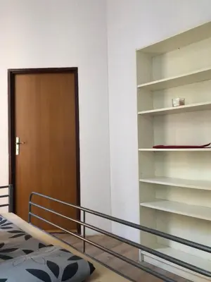 a bedroom with a bed and a door and shelves at Caramba in Kraków