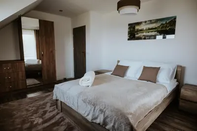 a bedroom with a large bed and a mirror at Wzgórze Marzeń in Zembrzyce