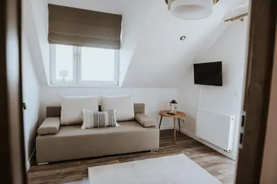 a living room with a couch and a window at Wzgórze Marzeń in Zembrzyce