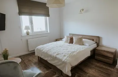 a bedroom with a bed with white sheets and pillows at Wzgórze Marzeń in Zembrzyce