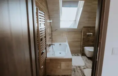 a bathroom with a tub and a toilet and a window at Wzgórze Marzeń in Zembrzyce