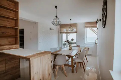 a kitchen and dining room with a wooden table and chairs at Wzgórze Marzeń in Zembrzyce