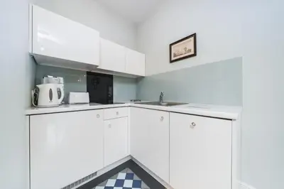 a kitchen with white cabinets and a sink at In The Heart Of Jewish Quarter - Old Synagogue - by Upstairs in Kraków