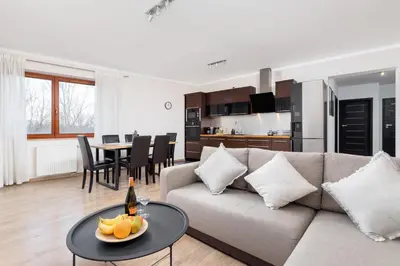 a living room with a couch and a table with fruit on it at Dzielnica XIII Podgórze Kraków by Noclegi Renters in Kraków
