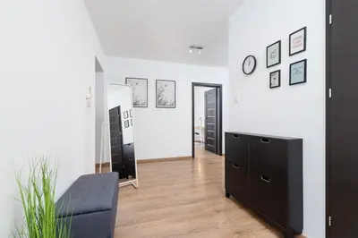 a living room with a black dresser and a mirror at Dzielnica XIII Podgórze Kraków by Noclegi Renters in Kraków