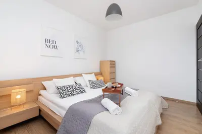 a bedroom with two beds and a night stand at Dzielnica XIII Podgórze Kraków by Noclegi Renters in Kraków