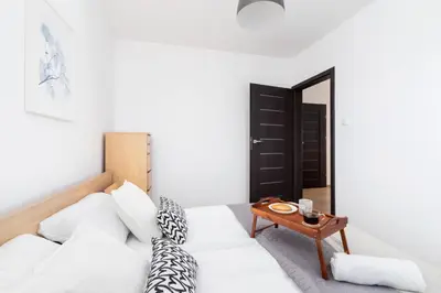 a living room with a white couch and a table at Dzielnica XIII Podgórze Kraków by Noclegi Renters in Kraków