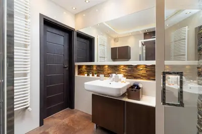 a bathroom with a white sink and a black door at Dzielnica XIII Podgórze Kraków by Noclegi Renters in Kraków