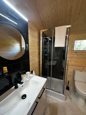 a bathroom with a white sink and a shower at Domek na Wiejskiej in Zator