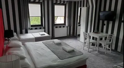 a bedroom with two beds and a table and a desk at NATA Pokoje Gościnne Restauracja in Libiąż